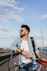 Smiling guy with bicycle and smartphone - ADSF03275