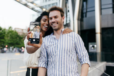 Schöne schwarze Frau und gut aussehend kaukasischen Mann posiert für selfie während stehend auf dem Hintergrund der modernen Stadt - ADSF03347