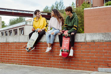 Teenagers with skateboards on fence - ADSF03371