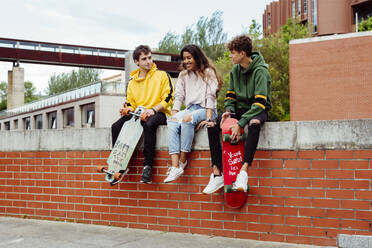 Teenagers with skateboards on fence - ADSF03373