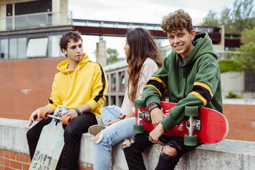 Teenagers with skateboards on fence - ADSF03374