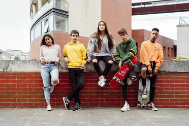 Teenagers with skateboards on fence - ADSF03375