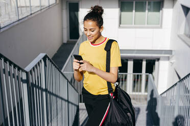 Sportliche Frau beim Surfen auf dem Smartphone - ADSF03493