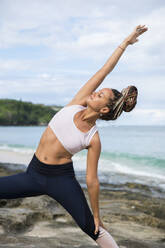 Woman stretching and posing at seaside - ADSF03559