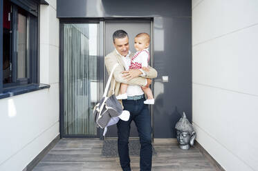 Father holding his baby boy and leaving home - JCMF01027