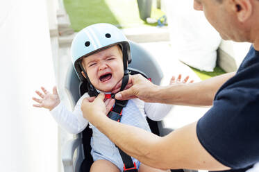 Father with son sitting in safety seat of bicycle - JCMF01043