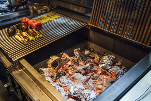 Holzkohle und gegrilltes Gemüse in der Restaurantküche - OCMF01494