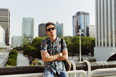 Man with arms crossed on bridge - ADSF03593