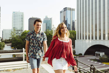 Couple holding hands and walking on street - ADSF03600