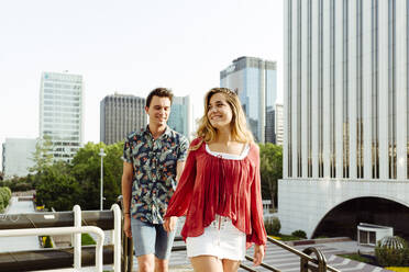 Couple holding hands and walking on street - ADSF03601