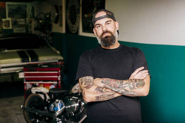 Tattooed mechanic in garage - ADSF03687