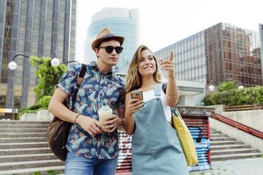 Couple browsing smartphone on street - ADSF03759