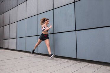 Sportliche Frau joggt auf der Straße - ADSF03874