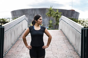 Junge Frau beim Training auf der Brücke mit Blick zur Seite - JMPF00234