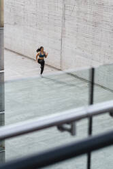 Junge Frau joggt auf dem Platz - JMPF00239