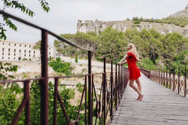 Frau in rotem Kleid auf der Sankt-Paul-Brücke in Cuenca, Spanien - MRRF00126