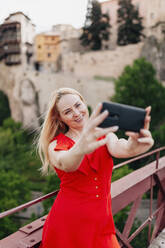 Woman taking selfie on Saint Paul Bridge in Cuenca, Spain - MRRF00136