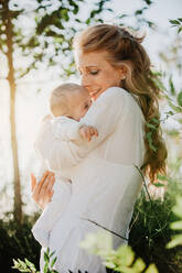 Grandma kissing her grandson in the park - ADSF04118