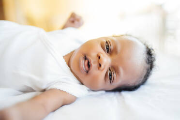 Close-up of newborn baby girl lying on bed at home - OCMF01525