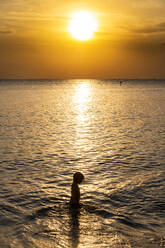 Vietnam, Insel Phu Quoc, Strand Ong Lang, Silhouette eines Mädchens im Meer bei Sonnenuntergang - RUNF03939