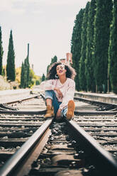 African-American woman laughing in the tracks of a train - ADSF04140