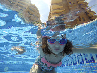 Nahaufnahme eines Mädchens, das unter Wasser im Pool schwimmt - EGAF00551