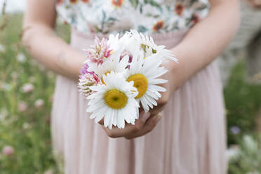 Nahaufnahme eines Mädchens, das im Freien stehend Blumen hält - EYAF01219
