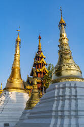Myanmar, Yangon, Golden spires of Shwedagon pagoda against clear sky - RUNF03984