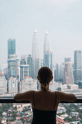 Frau zu Hause mit Blick auf Wolkenkratzer - ADSF04411