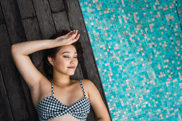 Lächelnde Frau entspannt am Pool - ADSF04413