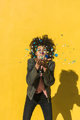 Black woman with afro hair throwing confetti to celebrate a very special day - ADSF04503