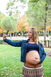 Schwangere attraktive Frau mit Mobiltelefon - ADSF04545