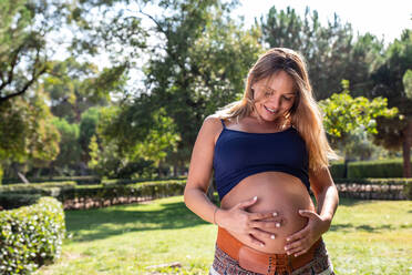 Smiling pregnant attractive woman in park - ADSF04552