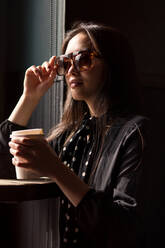 Woman in sunglasses having coffee - ADSF04554