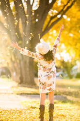 Girl with upping hands tossing leaves - ADSF04678