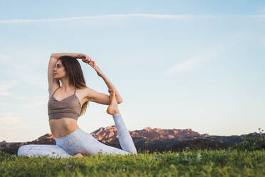 Frau dehnt sich und macht Yoga auf dem Feld - ADSF04789