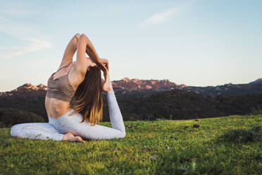 Frau dehnt sich und macht Yoga auf dem Feld - ADSF04790