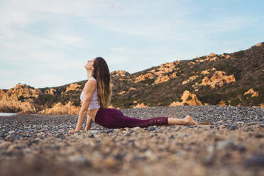 Woman with closed eyes doing yoga asana meditation on the beach. Female in  sport clothes sitting in lotus pose on mat at sunset stock photo (259943) -  YouWorkForThem