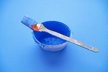 Studio shot of paintbrush on top of bucket with blue paint - PPXF00304