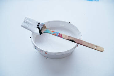 Studio shot of paintbrush on top of bucket with white paint - PPXF00305