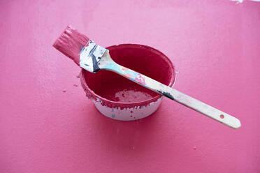 Studioaufnahme eines Pinsels auf einem Eimer mit rosa Farbe - PPXF00306