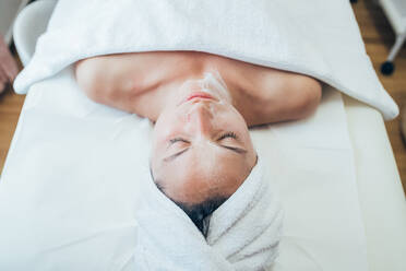 Woman lying on treatment bed in a beauty salon. - CUF56182