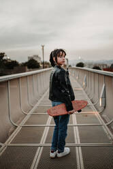 Girl with skateboard on walkway - ADSF04867