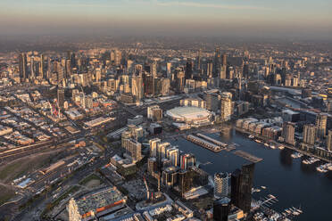 Luftaufnahme von West Melbourne bei Sonnenuntergang mit Blick auf das Melbourner Stadtzentrum und die Docklands, Austrialia. - AAEF09149