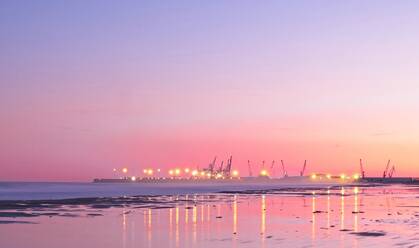Lichter von modernen Schiffen leuchten in der Ferne auf dem Hintergrund des Sonnenuntergangs. - ADSF05115