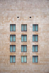 Light brown brick wall of building with little similar closed windows in Bilbao - ADSF05120