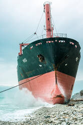 Riesiges Metallschiff in Küstennähe vor bewölktem blauem Himmel - ADSF05273