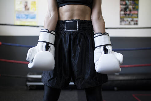 Gesichtslose Frau in Sportkleidung, die sich in einem Fitnessstudio mit professionellen Geräten aufhält - ADSF05310