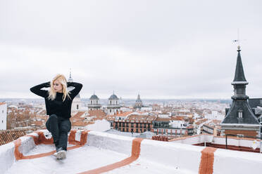 Junge blonde Frau steht auf dem Dach - ADSF05316