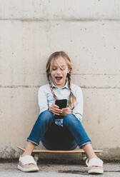 Kid using mobile phone with skate - ADSF05344